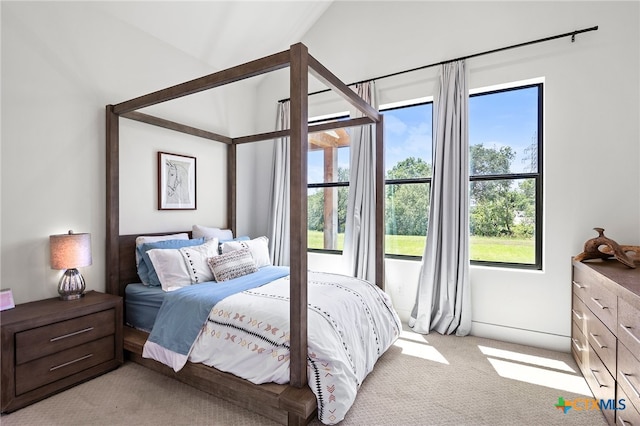 bedroom featuring vaulted ceiling and light carpet