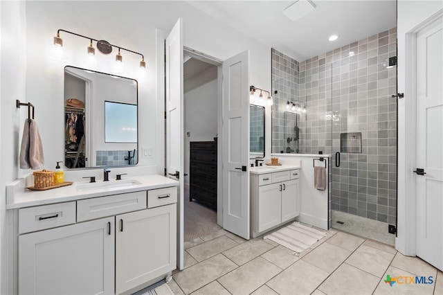 bathroom featuring tile patterned flooring, vanity, and a shower with door