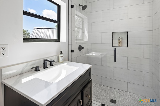 bathroom featuring a shower with shower door and vanity