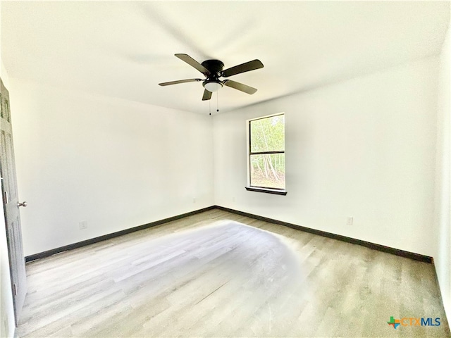 empty room with ceiling fan and light hardwood / wood-style flooring