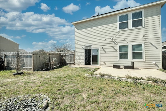 rear view of house featuring a fenced backyard, a patio, and a yard