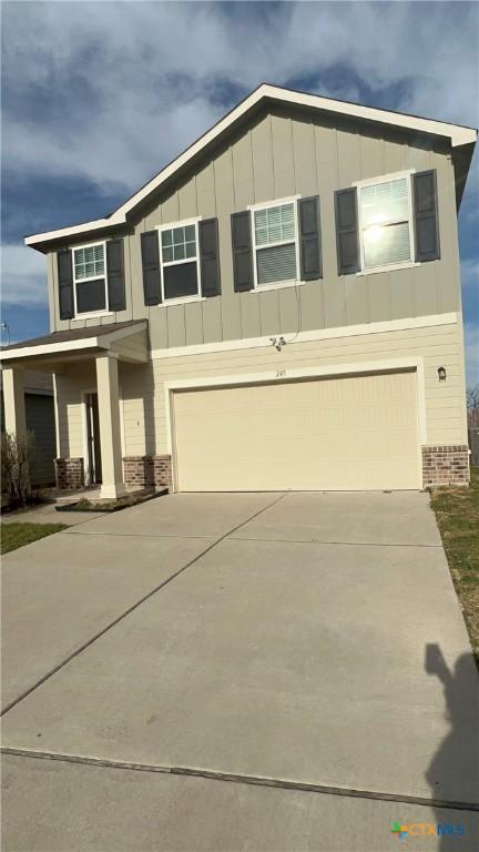 view of front facade with driveway, board and batten siding, and an attached garage