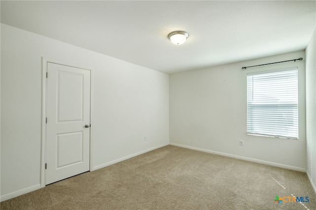 unfurnished room featuring baseboards and carpet floors