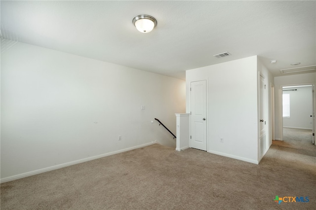 empty room with visible vents, baseboards, and light colored carpet