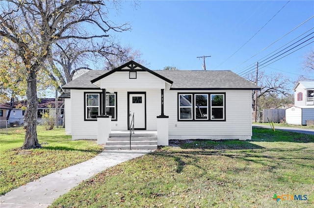 bungalow-style home with a front yard