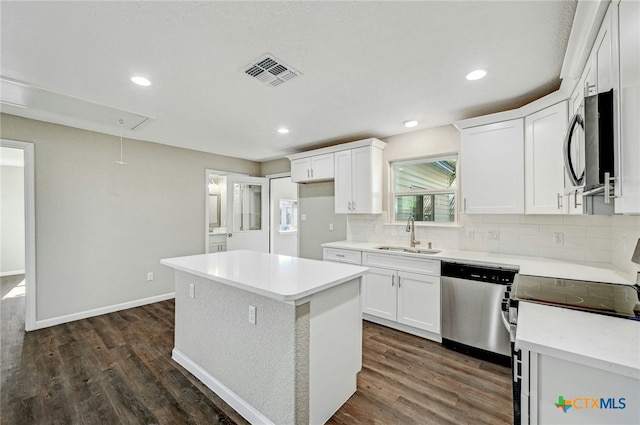 212 S Walnut Ave, Luling, TX 78648 - kitchen featuring stainless steel appliances, a center island, dark wood-type flooring, white cabinetry, and recessed lighting