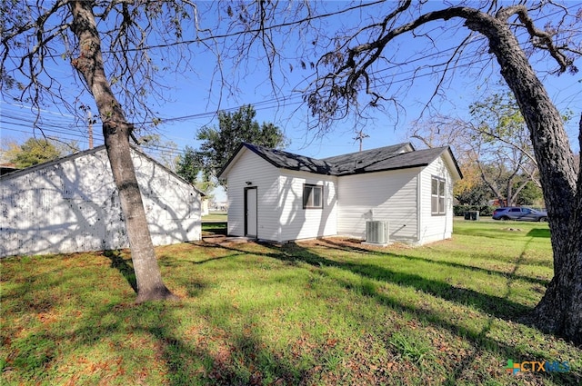 rear view of house with a yard and central AC unit