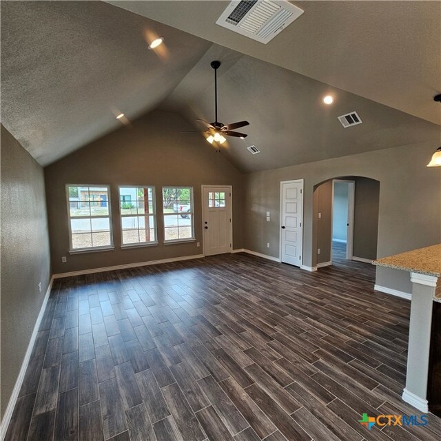 unfurnished living room featuring a textured ceiling, dark wood-type flooring, ceiling fan, and lofted ceiling