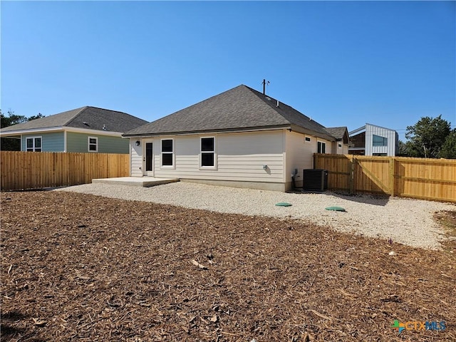 back of house with a patio, a fenced backyard, central air condition unit, a shingled roof, and a gate