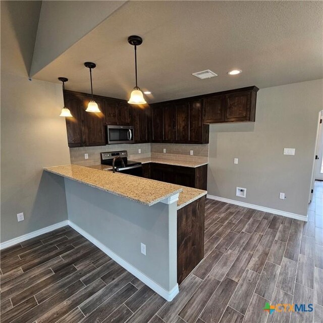 kitchen featuring appliances with stainless steel finishes, wood finish floors, baseboards, and recessed lighting