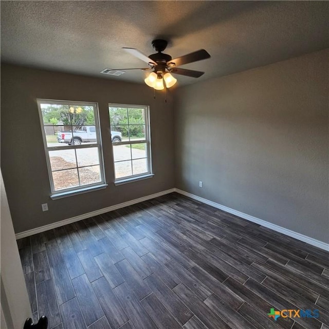 spare room featuring dark wood-style floors, ceiling fan, baseboards, and a textured ceiling