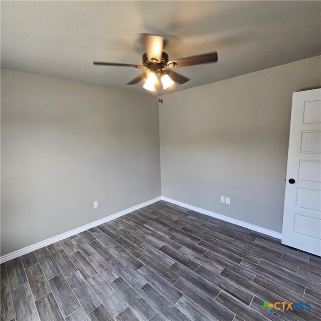 empty room featuring ceiling fan, a textured ceiling, and dark hardwood / wood-style floors