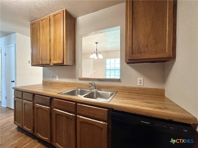 kitchen featuring hanging light fixtures, butcher block counters, black dishwasher, and sink