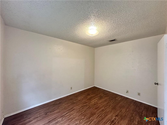 unfurnished room with hardwood / wood-style floors and a textured ceiling