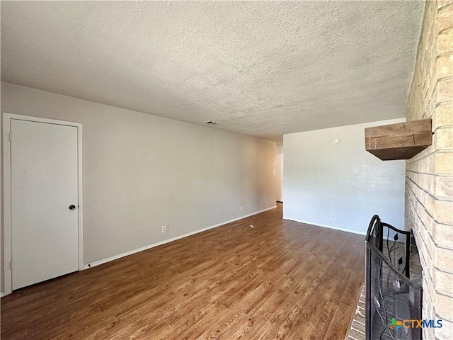 unfurnished living room featuring wood-type flooring and a textured ceiling