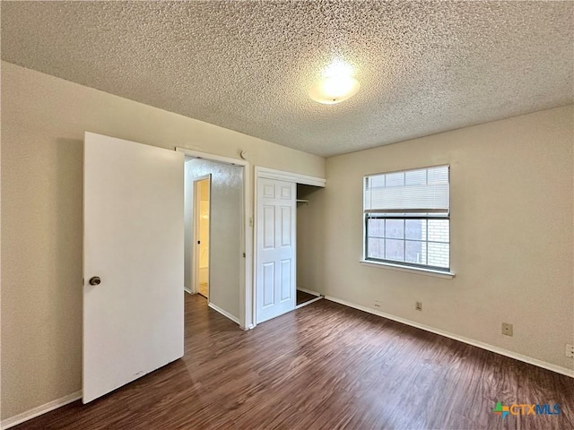 unfurnished bedroom featuring dark wood-type flooring, a closet, and a textured ceiling