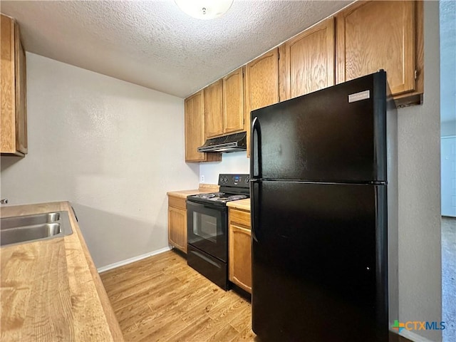 kitchen featuring sink, a textured ceiling, light wood-type flooring, and black appliances