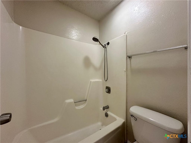 bathroom with toilet, bathing tub / shower combination, and a textured ceiling