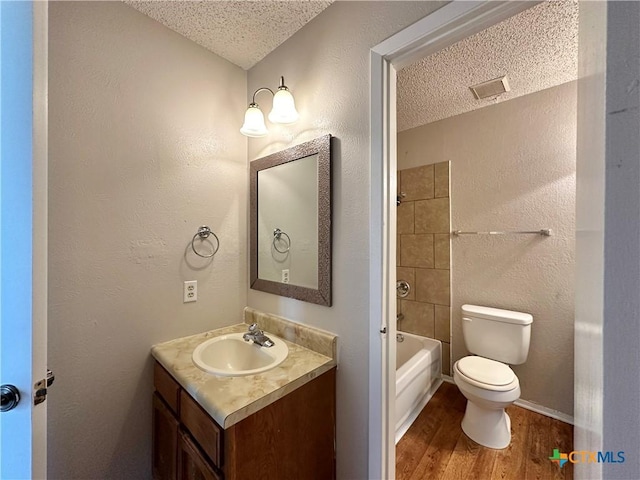 bathroom featuring vanity, hardwood / wood-style floors, toilet, and a textured ceiling