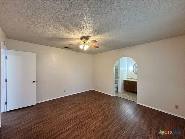 unfurnished room featuring dark wood-type flooring, a textured ceiling, and ceiling fan