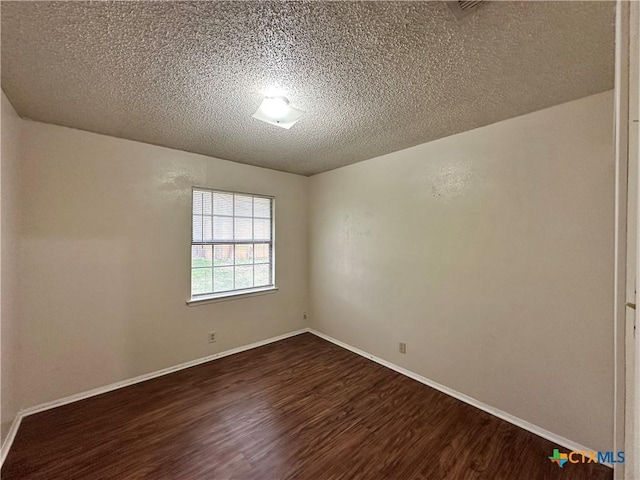 unfurnished room featuring dark wood-type flooring and a textured ceiling