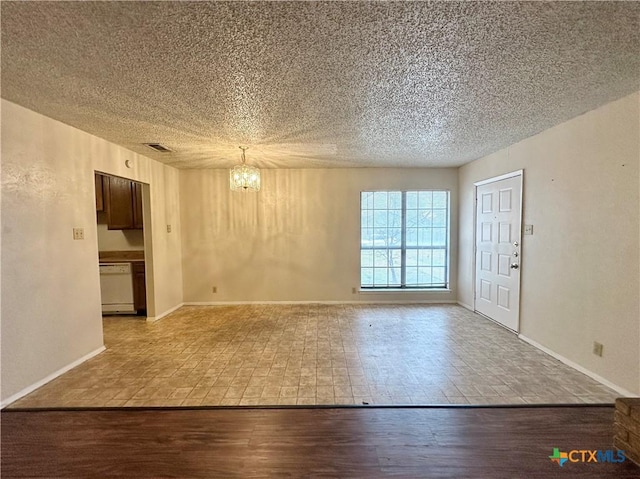 empty room featuring an inviting chandelier, wood-type flooring, and a textured ceiling