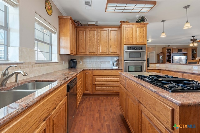 kitchen featuring ornamental molding, stainless steel appliances, sink, hardwood / wood-style floors, and hanging light fixtures