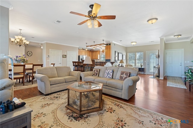 living room with crown molding, hardwood / wood-style floors, and ceiling fan with notable chandelier