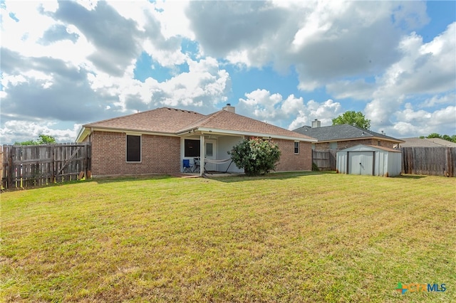 back of house with a storage unit, a yard, and a patio area