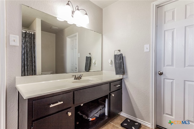 bathroom featuring tile patterned flooring, vanity, and toilet