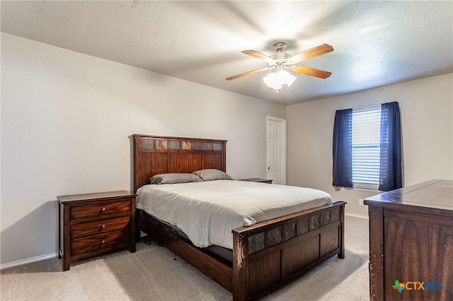 bedroom with ceiling fan, a textured ceiling, and light carpet