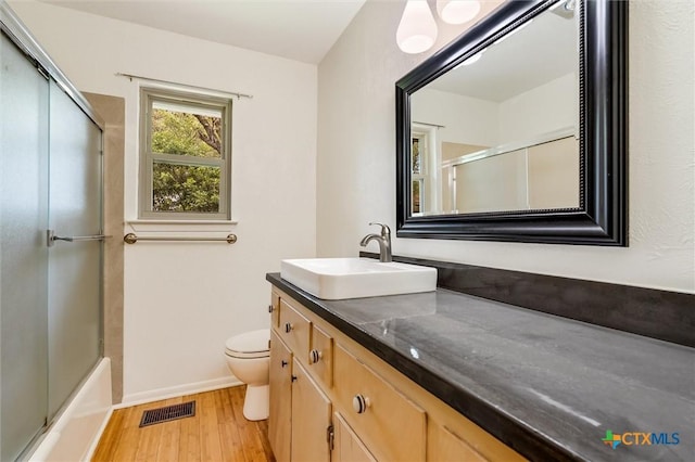 123 E Sierra Cir, San Marcos, TX 78666 - full bathroom featuring wood finished floors, vanity, and enclosed tub / shower combo