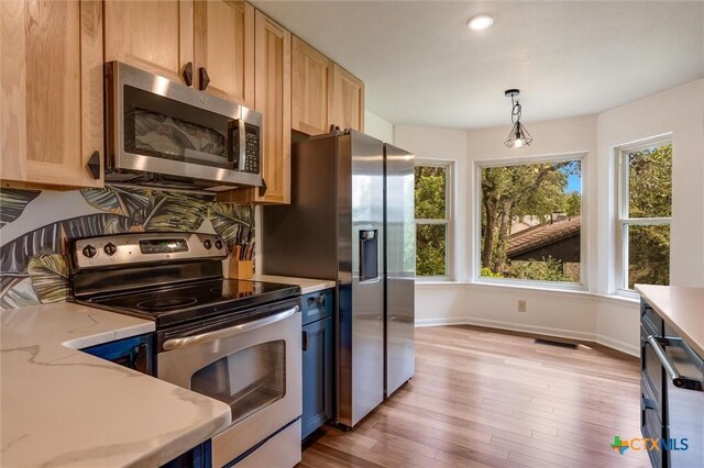 123 E Sierra Cir, San Marcos, TX 78666 - kitchen with stainless steel appliances, plenty of natural light, light wood-style flooring, and hanging light fixtures