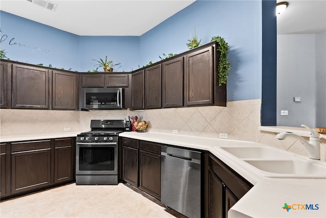 kitchen featuring appliances with stainless steel finishes, tasteful backsplash, dark brown cabinets, and sink