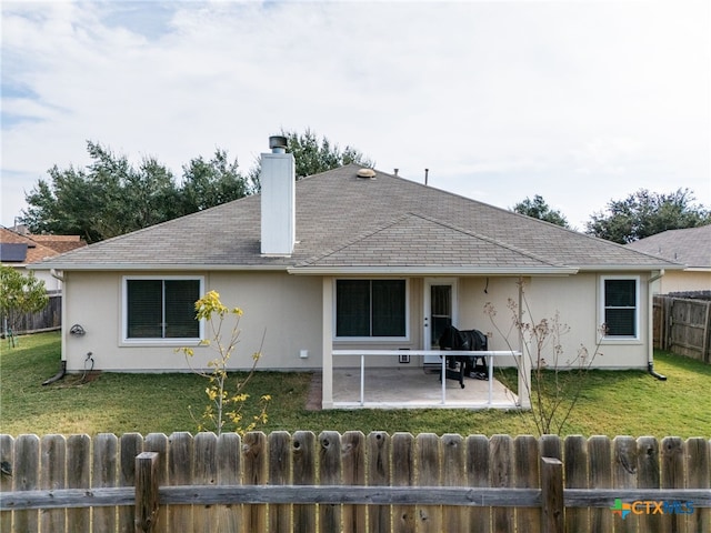 rear view of property featuring a lawn and a patio