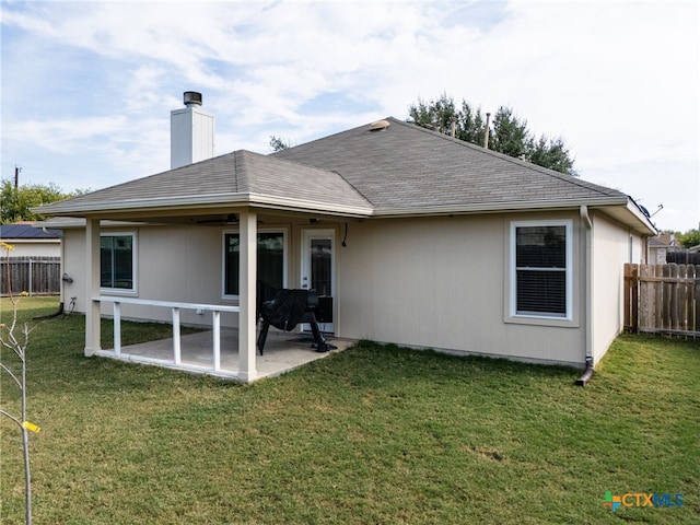 back of house featuring a lawn and a patio