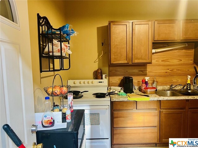 kitchen featuring white range oven and sink