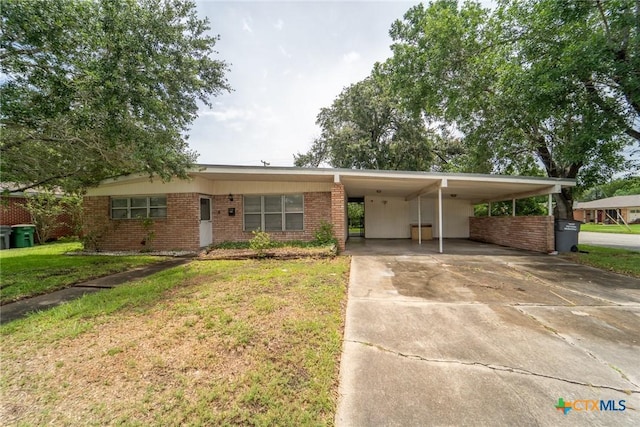 3001 Hummingbird St, Victoria, TX 77901 - view of front facade with an attached carport, brick siding, a front yard, and driveway