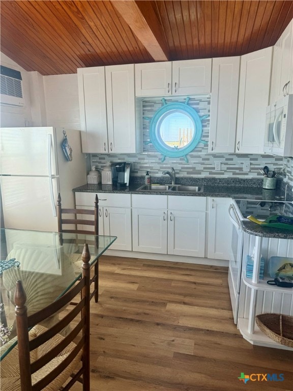 kitchen featuring hardwood / wood-style floors, sink, backsplash, white cabinetry, and white appliances