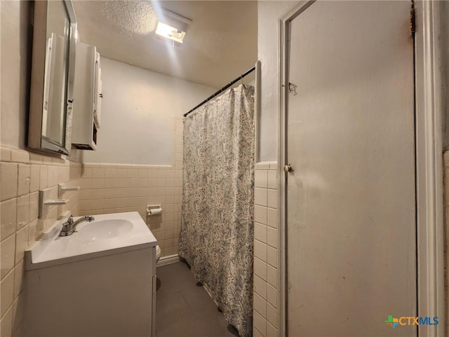 4305 Willow St, Corpus Christi, TX 78411 - full bath featuring tile walls, vanity, a wainscoted wall, and curtained shower