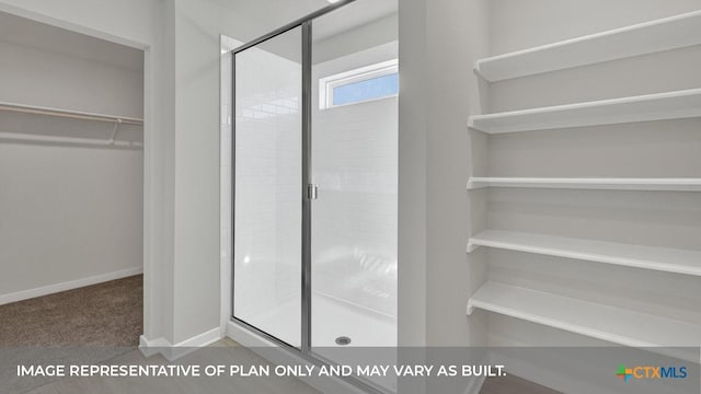 620 Radley Rd, Lockhart, TX 78644 - bathroom with a shower stall, a walk in closet, and baseboards