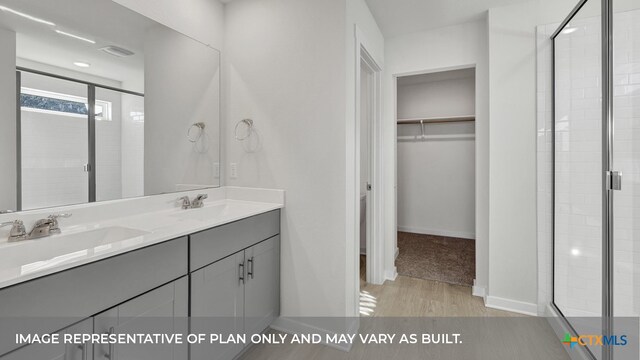 bathroom with hardwood / wood-style floors, walk in shower, and vanity