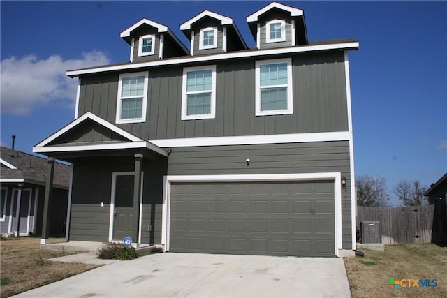 view of front facade with an attached garage, driveway, fence, and central AC