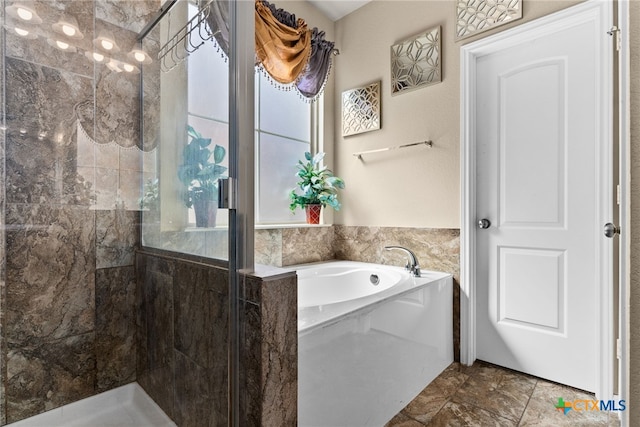 bathroom featuring a garden tub and a shower stall