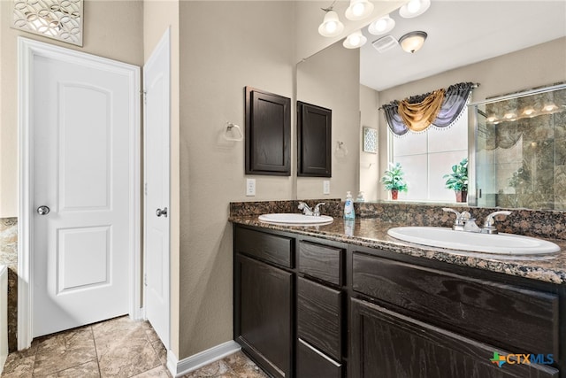 full bathroom featuring double vanity, visible vents, tiled shower, and a sink