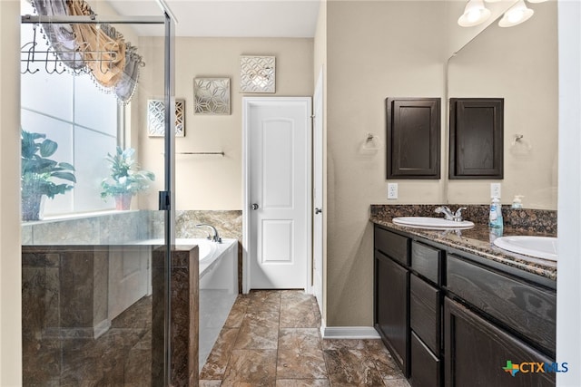 bathroom featuring an enclosed shower, double vanity, a bath, and a sink