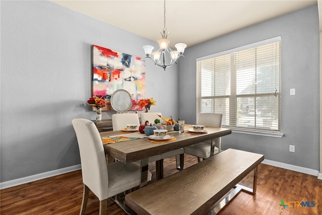 dining space with wood finished floors, baseboards, and a chandelier