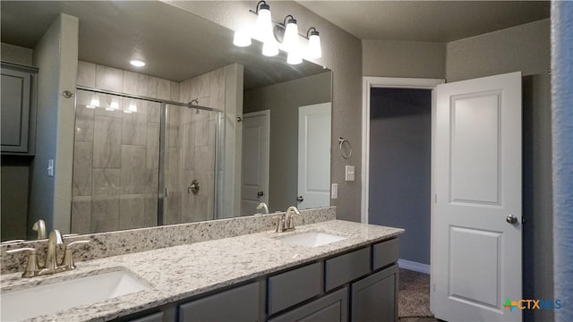 bathroom featuring a shower with door and vanity