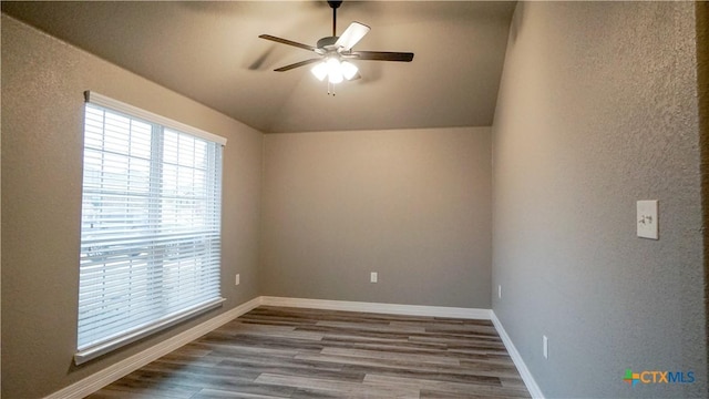 empty room with hardwood / wood-style flooring, vaulted ceiling, and ceiling fan