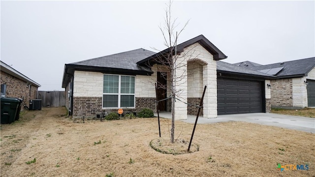 ranch-style house with central AC, a garage, and a front yard